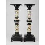A pair of ceramic columns, the ebonised plinths with ceramic floral columns between, 112cm high.