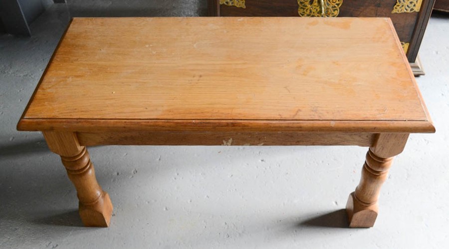 A pine coffee table with short turned legs.