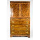 A walnut veneered gentleman's cabinet on chest, the two panelled doors above a brush slide, four
