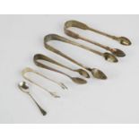 Four pairs of silver sugar tongs, and a mustard spoon.