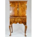 A Queen Anne style walnut cabinet on stand, with two doors inlaid with boxwood stringing, the base