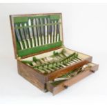 An oak cased canteen of cutlery, silver plated, with green baise lined interior, lower drawer.