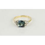 An 18ct gold and Quad A Tanzanite ring, cushion cut, flanked by three small diamonds to the