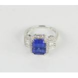 An 18ct gold, diamond and tanzanite ring, the rectangular cut central stone with square cut diamonds