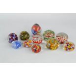 A quantity of eleven glass paperweights of various style and form.
