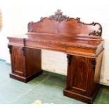 A Victorian mahogany side board, with crested back rail, frieze drawer, and two pedestal