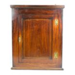 An 18th century oak corner cupboard with fielded panel door, and brass escutcheon, 91 by 74 by