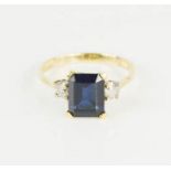 An 18ct gold and sapphire style ring, flanked by diamonds, 4.3g