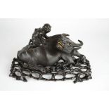 A fine 19th century Chinese hardwood carving of a man riding a buffalo, inset with bone eyes and