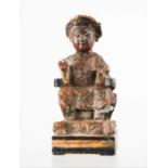 A Chinese wooden carved figure painted red and gold, 15cm high.