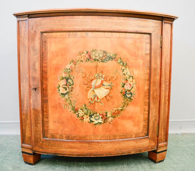 A 19th century Satinwood commode, with a painted musical group to the centre of the bowed door, 93