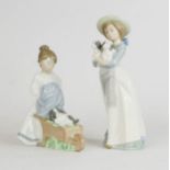 Two Nao figure groups, girl holding two dogs, and a girl with wheelbarrow carrying puppy, tallest