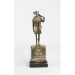 A silver model of a soldier, with engraved plaque to the front, 8cm high.