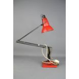A red angle poise lamp.