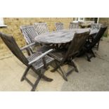 A teak garden table and eight chairs, together with six green striped chair cushions.