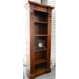 A large bookcase with carved heads and fluted columns, flanking the interior shelves.