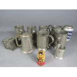 A quantity of pewter tankards and a lidded stoneware tankard.