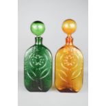 Two 1950s glass decanters, pressed with decoration, in green and amber.