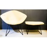 A 1950s Harry Bertoia wire diamond chair, with matching footstool, black patinated metal, with cream