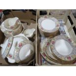 A Palissy gilt bordered dinner service with flower cartouches, vegetable dishes, gravy boat etc.