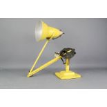 An angle poise lamp in yellow by Herbert Terry.