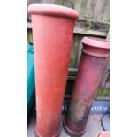 A pair of tall antique chimney pots.