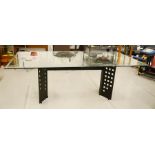 A designer glass top dining table, the black brushed chrome finish base in the Charles Rene