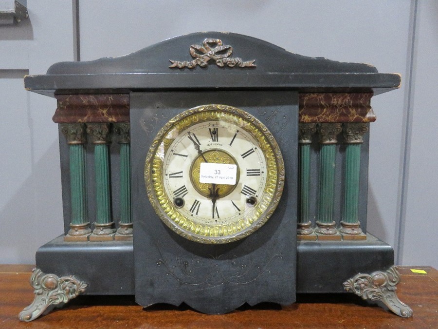 A mantle clock, with Roman Numeral dial, ebonised with pillars.