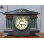 A mantle clock, with Roman Numeral dial, ebonised with pillars.