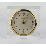 An Exclusive German alarm clock, set in perspex, Arabic dial, 8cm high.
