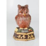 A small cast iron door stop in the form of an owl, hand painted.