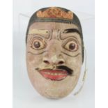 A Chinese carved and painted face mask.