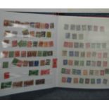 A red stamp album containing four penny reds.