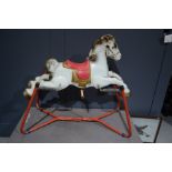 A 1950s tin horse on spring base.