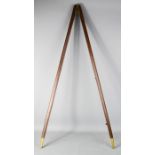 An antique wooden and brass pacing stick.