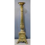 A brass torchere, on a triangular base, lion paw feet, floral swags and winged cherub heads 102cm