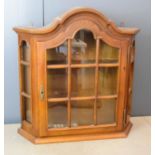 An oak wall cabinet with astrigal glazed doors.