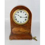 A mahogany mantle clock, with Swiss movement and Roman Numeral dial, with key.