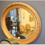 A giltwood oval mirror.