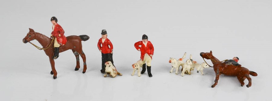 A group of painted lead figures; hunt and hounds, with two on horseback.