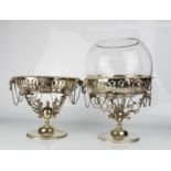 A pair of electroplate comports / centre pieces, cast with rams heads and raised on circular