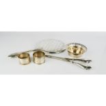 A silver hand mirror, a silver handled pair of glove stretches, two silver napkin rings and a silver