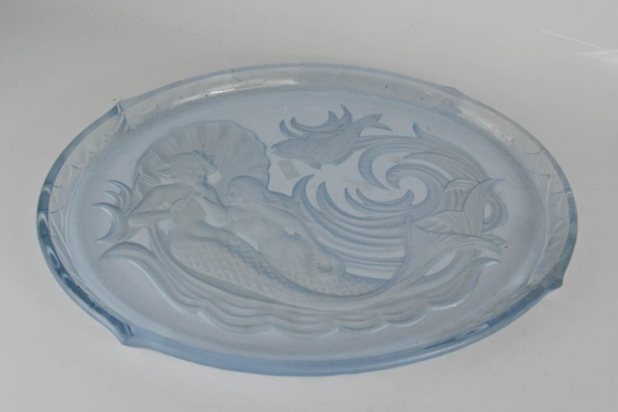 A glass tray, pressed with mermaids.