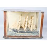 An oak cased model of a sailing clipper.