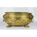 An oval brass jardinere with lion mask ring handles, and raised on paw feet, 33 by 26cm.