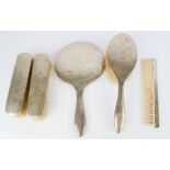A silver dressing table set; hairbrush, hand mirror, two clothes brushes and comb.
