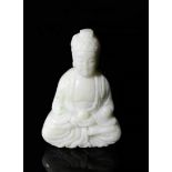 A Chinese hand carved white jade seated Buddha.