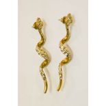 A pair of earrings, in the form of snakes.