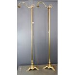 A pair of brass standard lamps with a swan neck and triangular base.