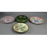 An enamelled bowl in green, together with three imari plates.